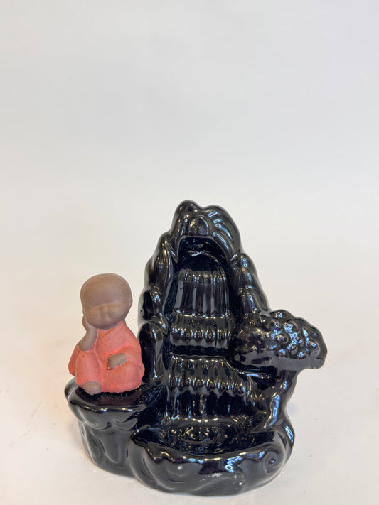 Quemador de incienso cascada con Buda Hermoso quemador de incienso en forma de cascada con figura de Buda, ideal para meditar, atraer paz y armonía al hogar. El humo desciende suavemente creando un efecto relajante y espiritual