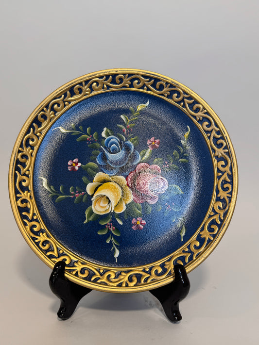 Plato Decorativo Floral Elegante plato en tonos azul y dorado, con delicado diseño de flores pintadas. Ideal para resaltar espacios y dar un toque clásico y artístico al hogar